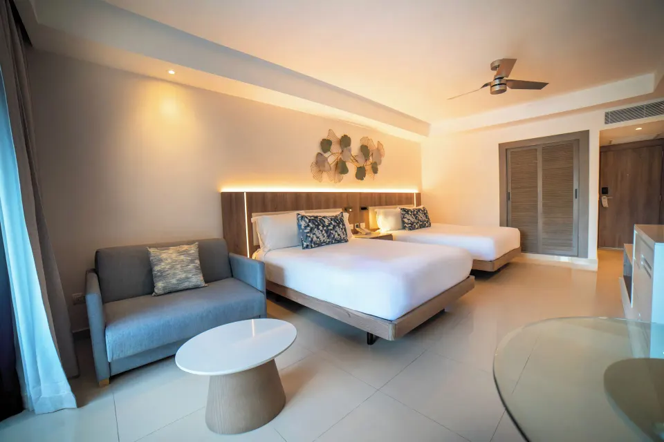 Luxury Room with two beds and gray sofa at Royalton Hideaway Punta Cana Resort & Casino.
