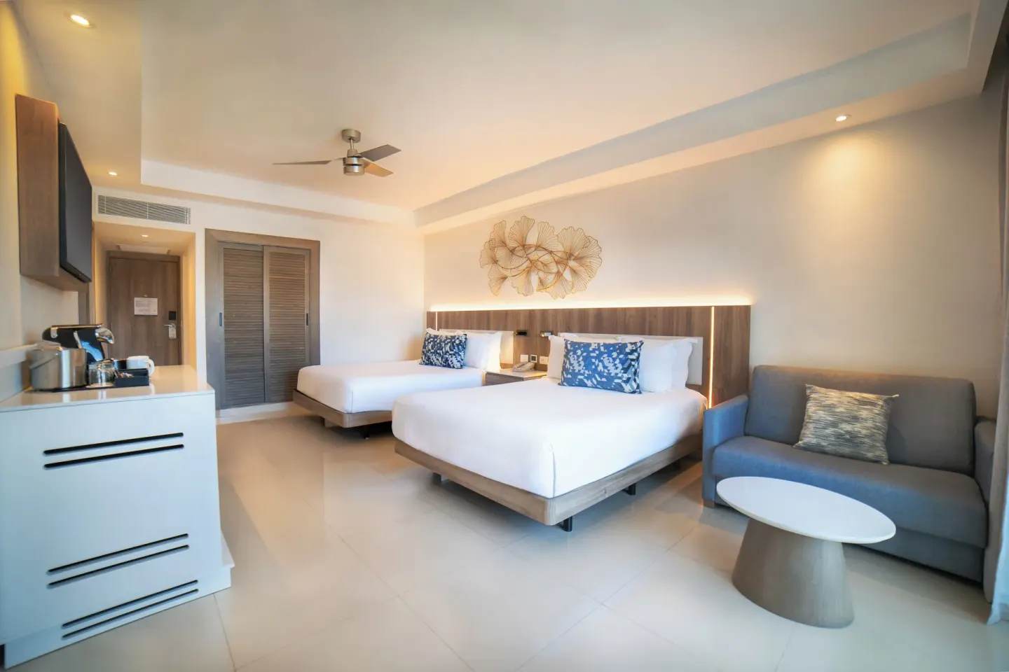 Luxury Room with two beds, sofa, and TV wall at Royalton Hideaway Punta Cana Resort & Casino.