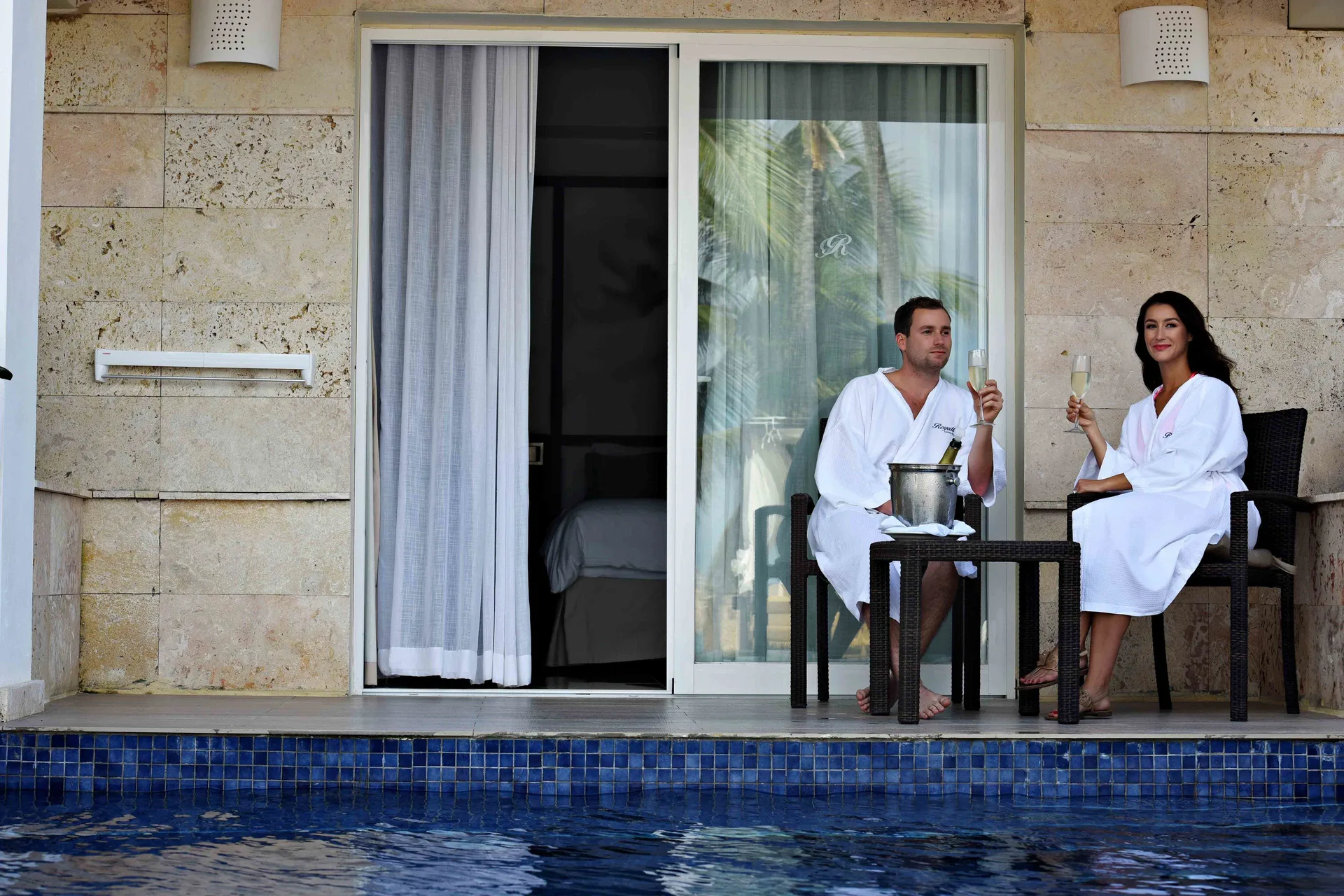 Guests toast on the swim-out terrace of a Luxury Swim Out Room at Royalton Hideaway Punta Cana Resort & Casino.