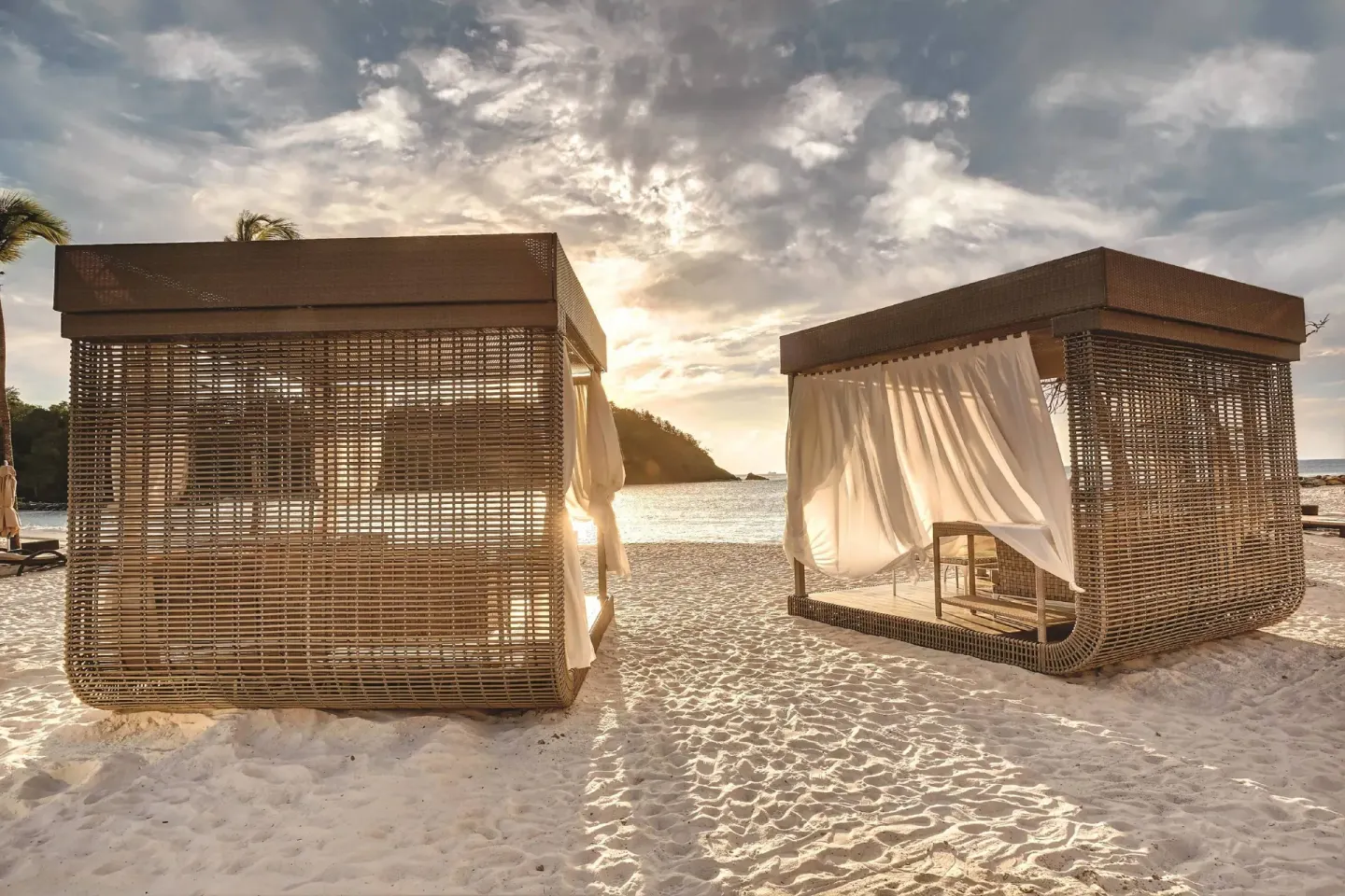 Beach cabanas with white curtains at sunset at Royalton Hideaway Saint Lucia.