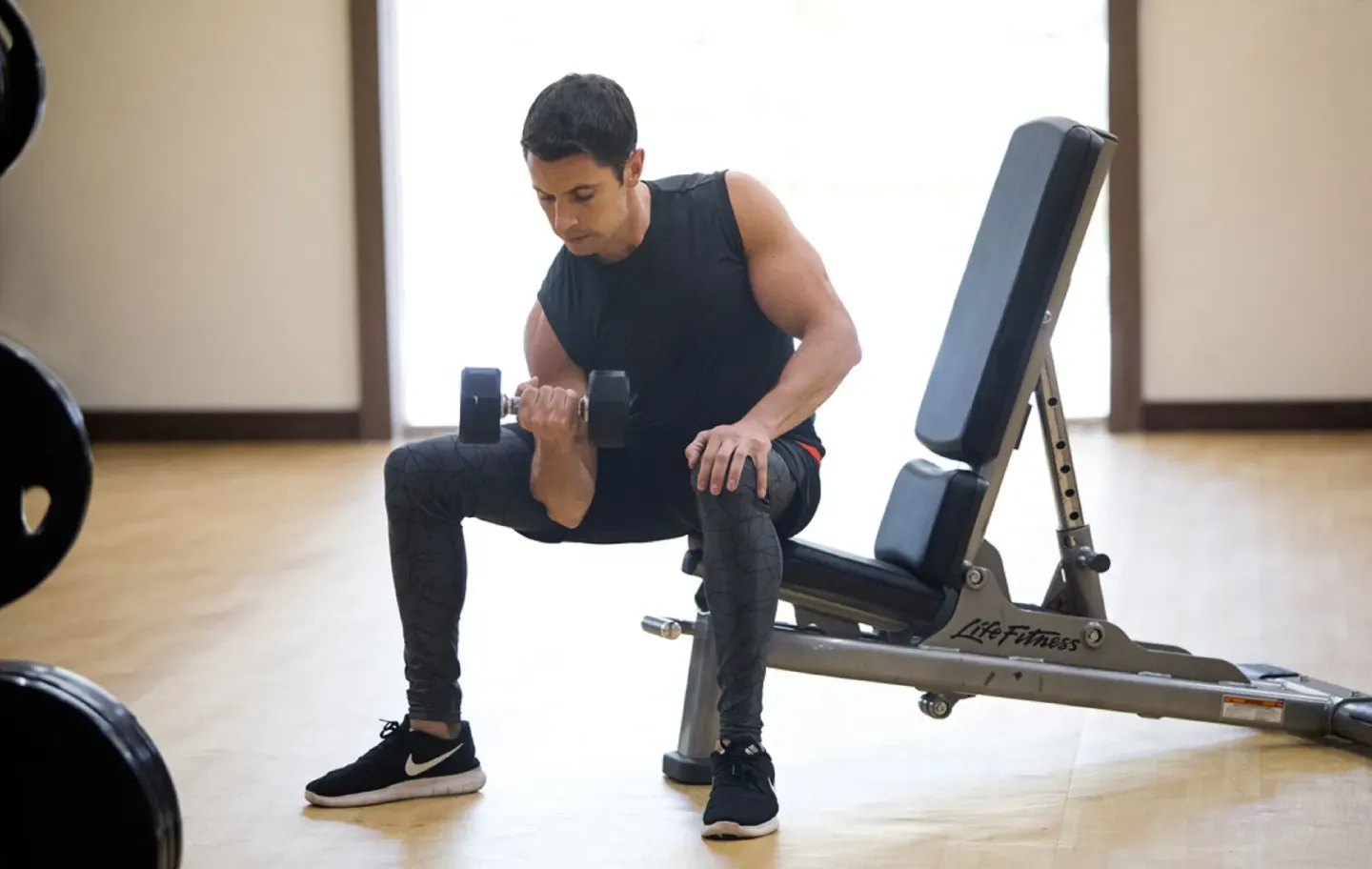 Man lifting a dumbbell beside a workout bench at Royalton Hideaway Saint Lucia.