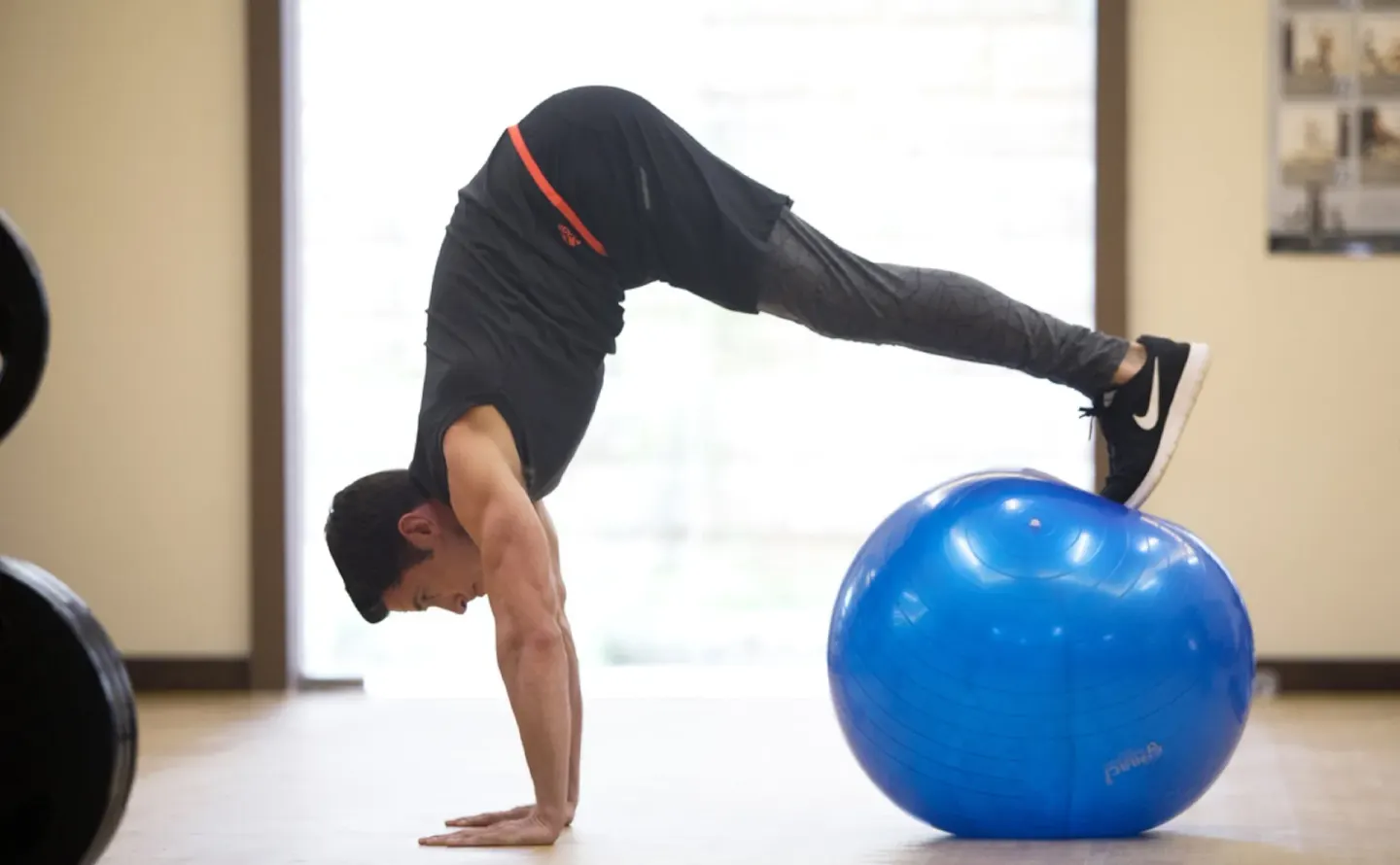 Man balancing on a blue exercise ball in the fitness area at Royalton Hideaway Saint Lucia.