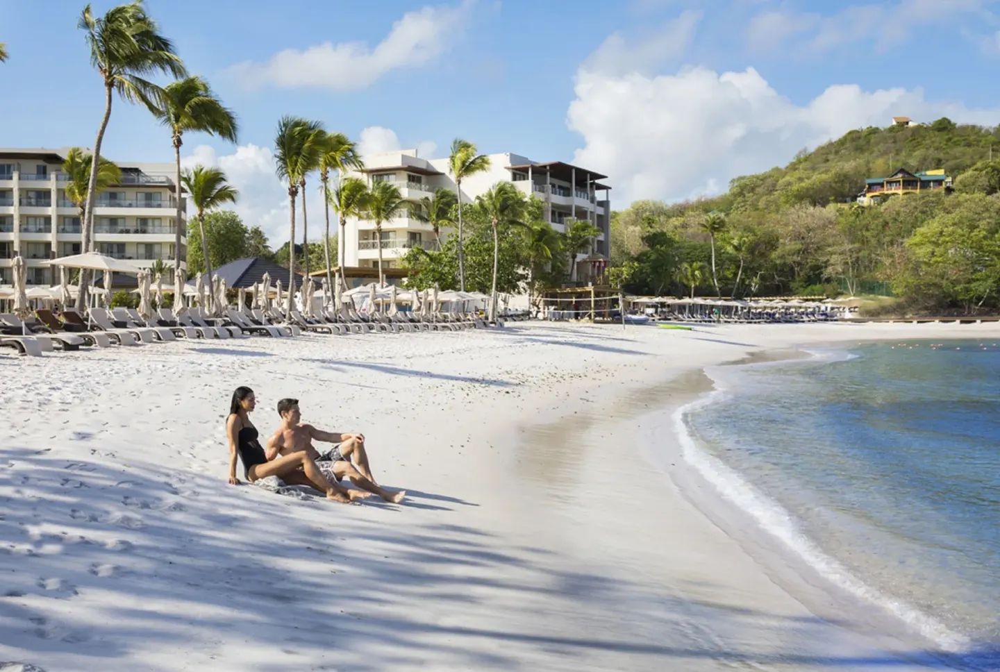 Guests sitting on the sandy beach at Royalton Hideaway Saint Lucia.