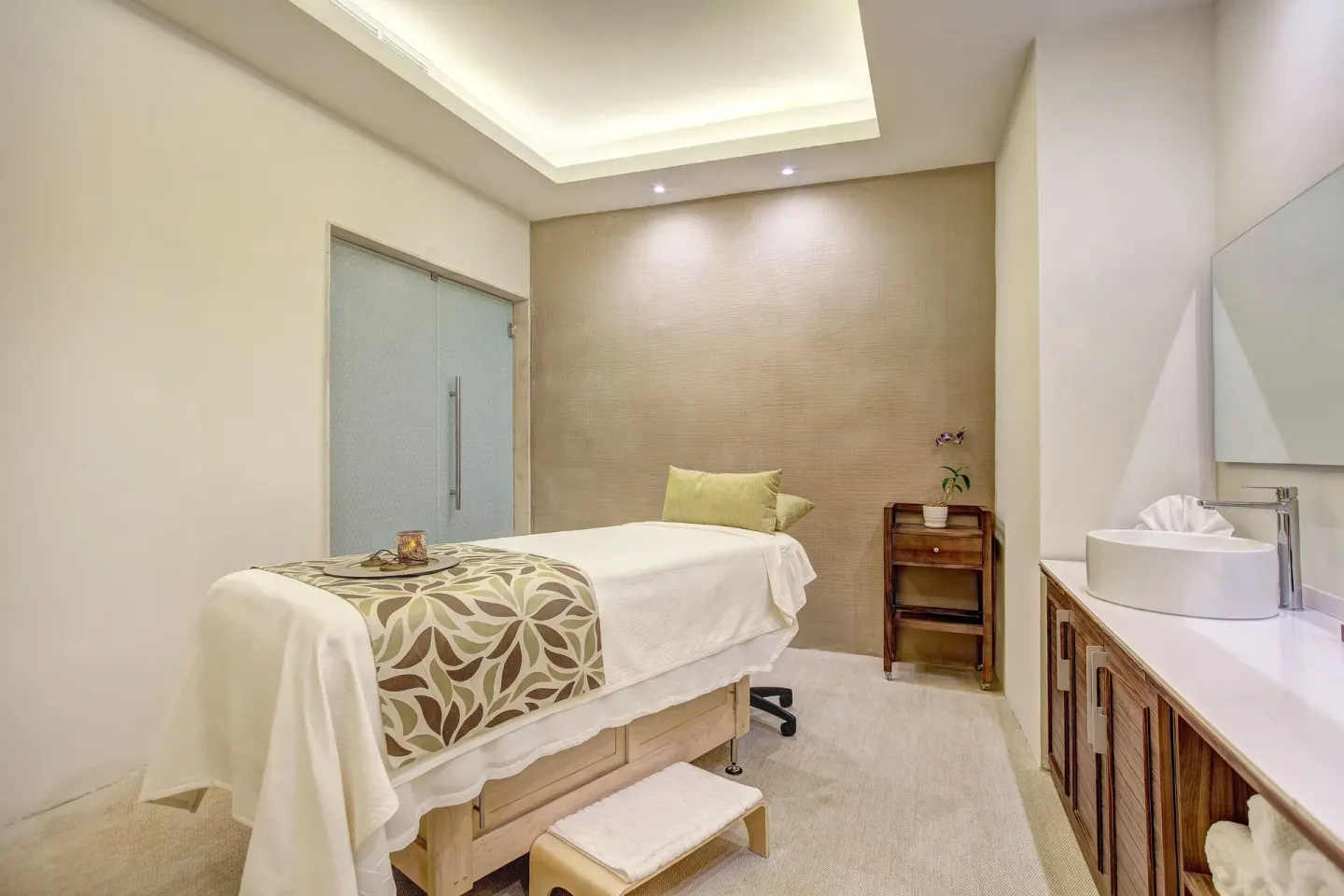 Spa treatment room with a massage table and sink at Royalton Hideaway Saint Lucia.