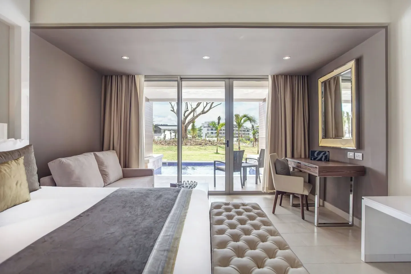 King bed, sofa, desk, and swim-out terrace in a suite at Royalton Hideaway Saint Lucia.