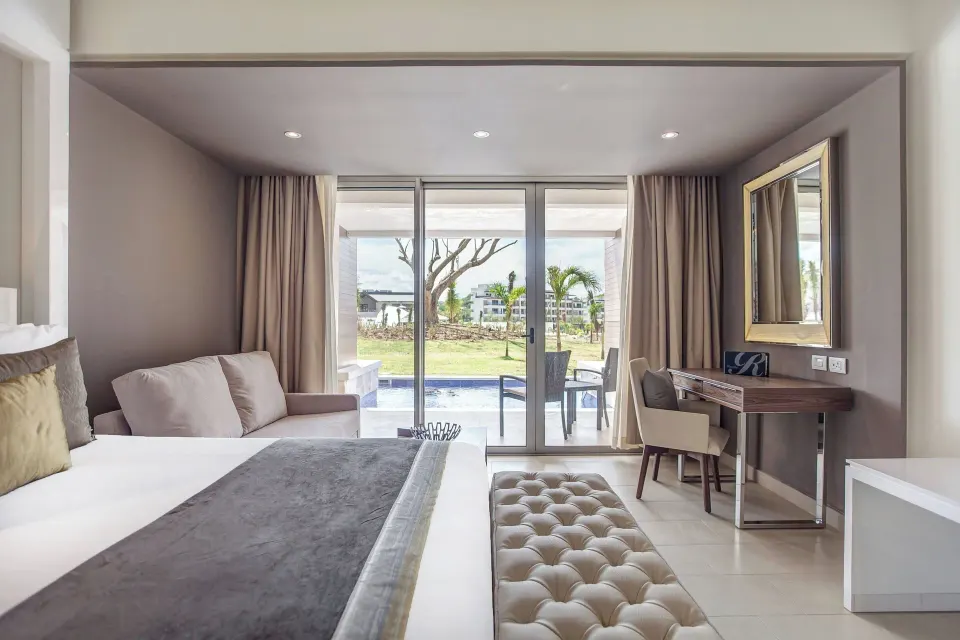 King bed, sofa, desk, and swim-out terrace in a suite at Royalton Hideaway Saint Lucia.
