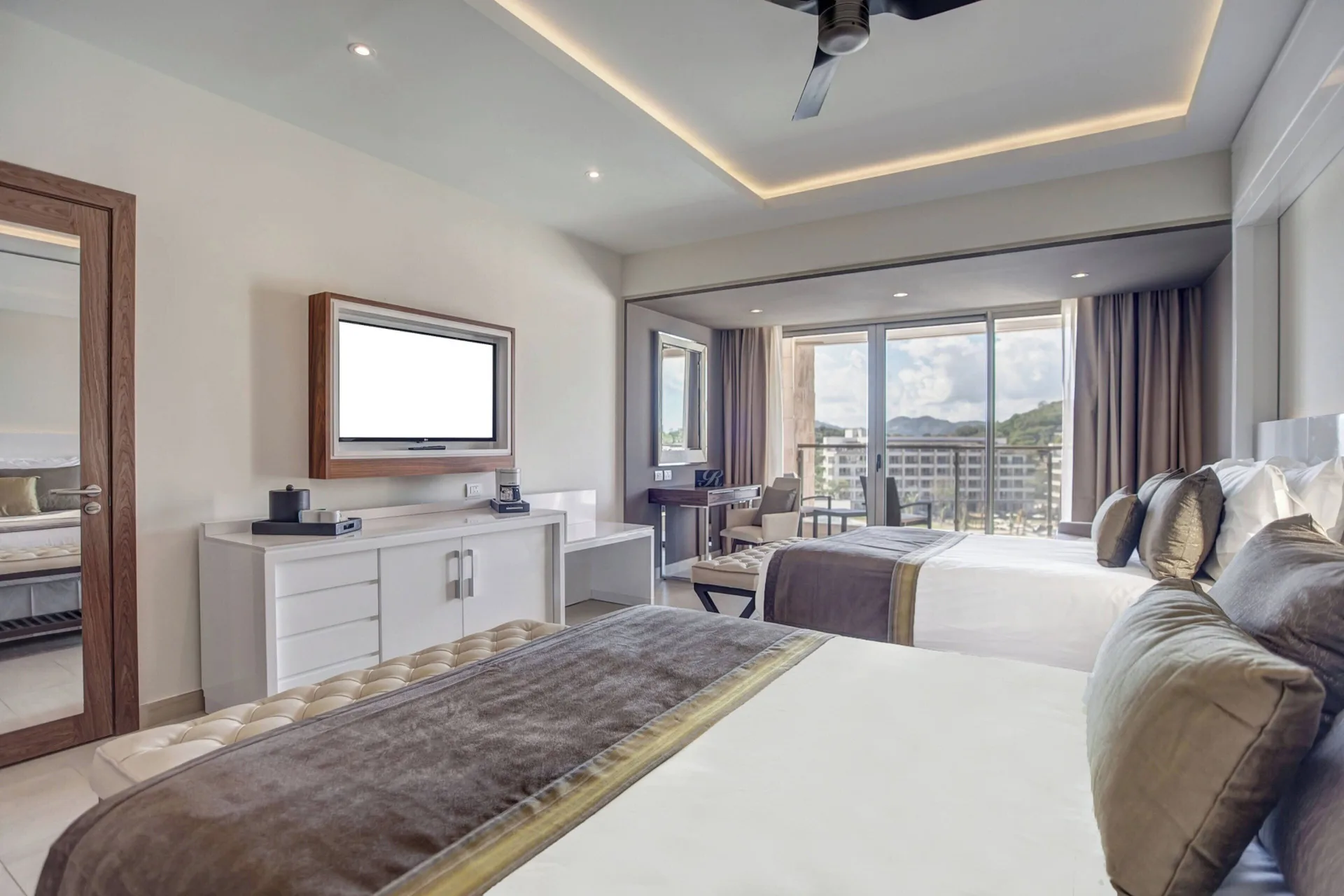 Two-bed suite with balcony doors, TV, and mountain view at Royalton Hideaway Saint Lucia.
