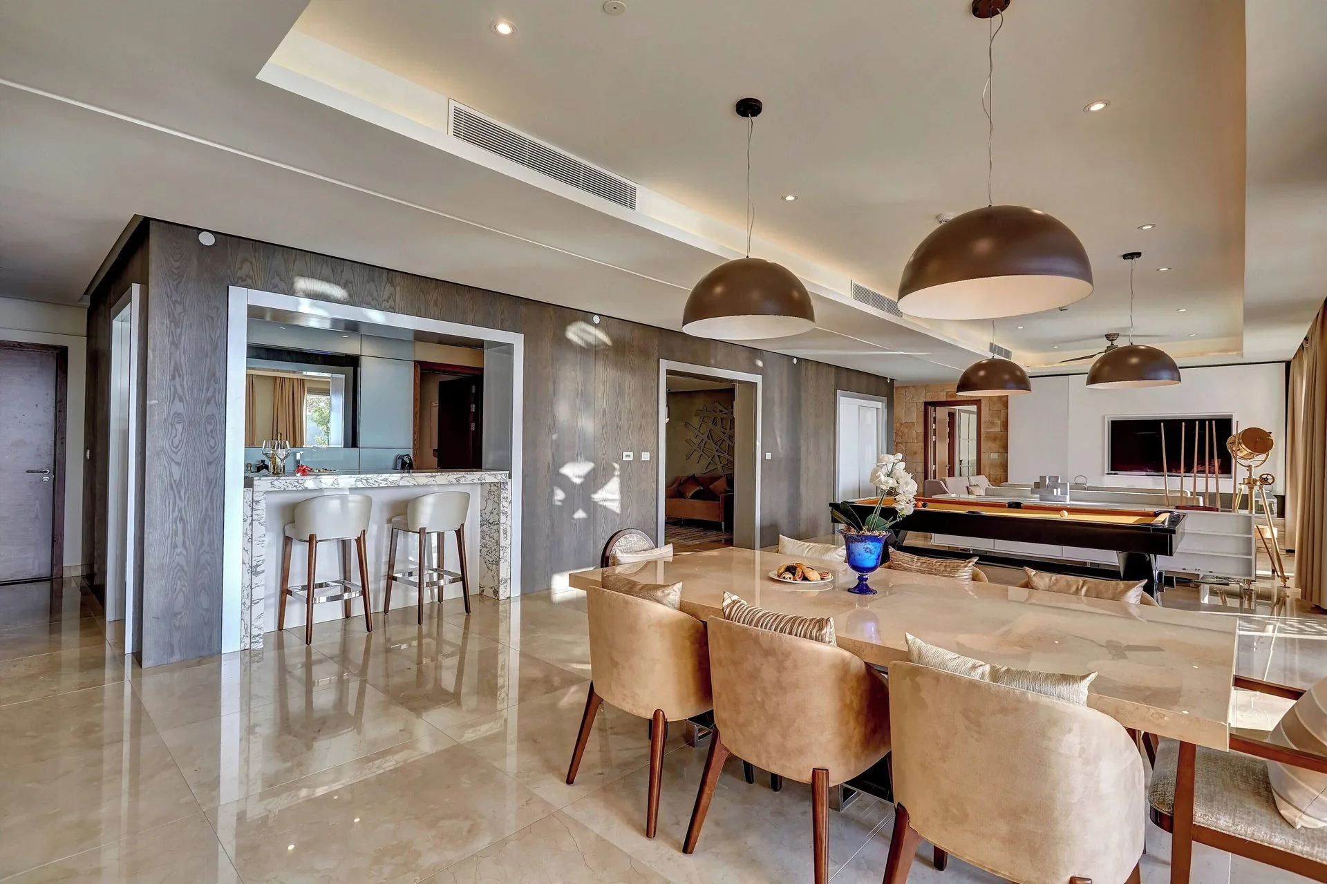 Suite dining area with bar seating and pool table at Royalton Hideaway Saint Lucia.