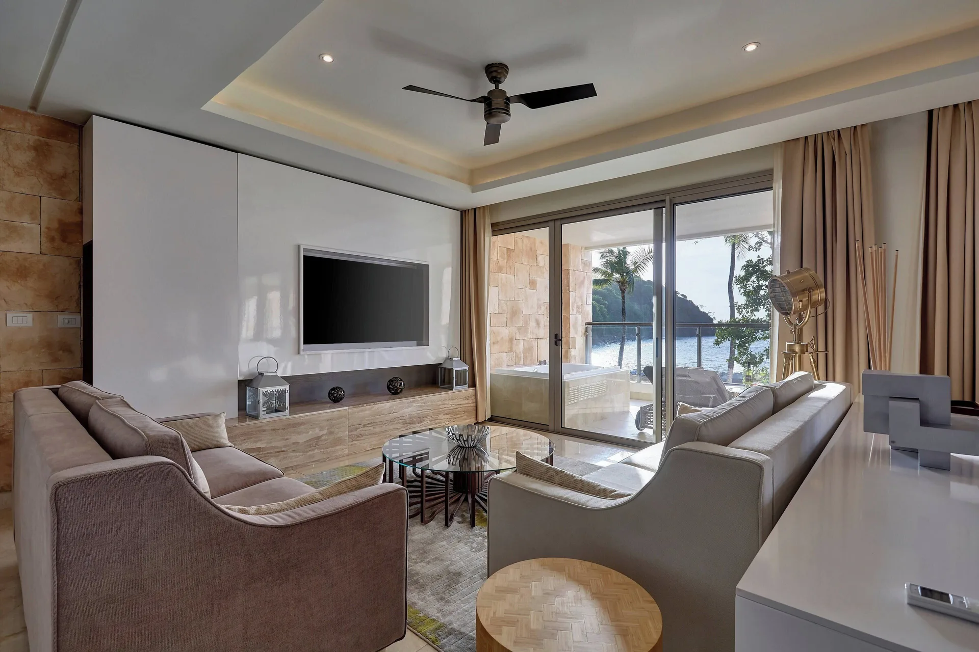 Suite living room with sofas, TV wall, and ocean balcony at Royalton Hideaway Saint Lucia.