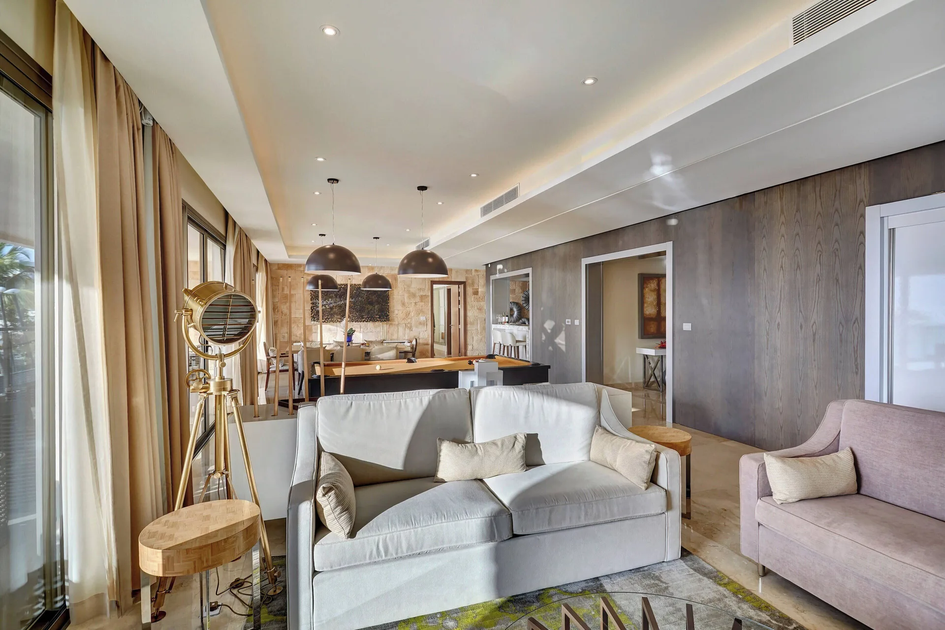 Suite living room with sofa and pool table at Royalton Hideaway Saint Lucia.