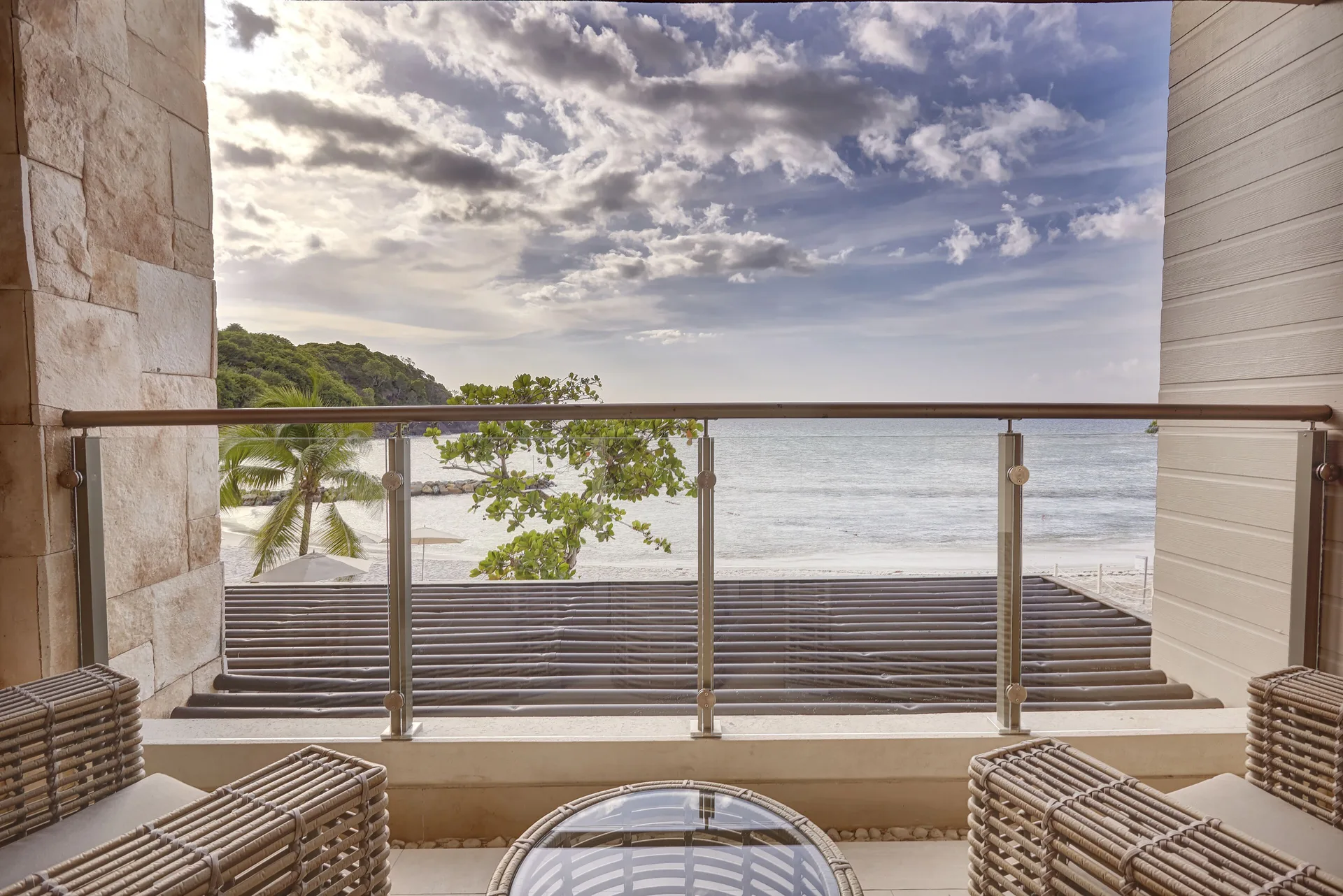 Oceanfront balcony seating with glass railing at Royalton Hideaway Saint Lucia.