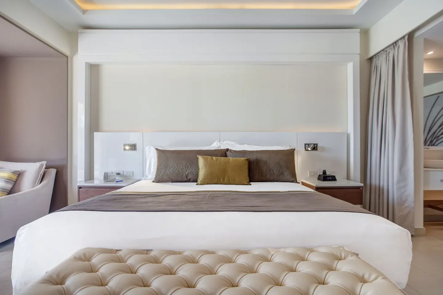 Luxury Junior Suite king bed between sitting and vanity areas at Royalton Hideaway Saint Lucia.