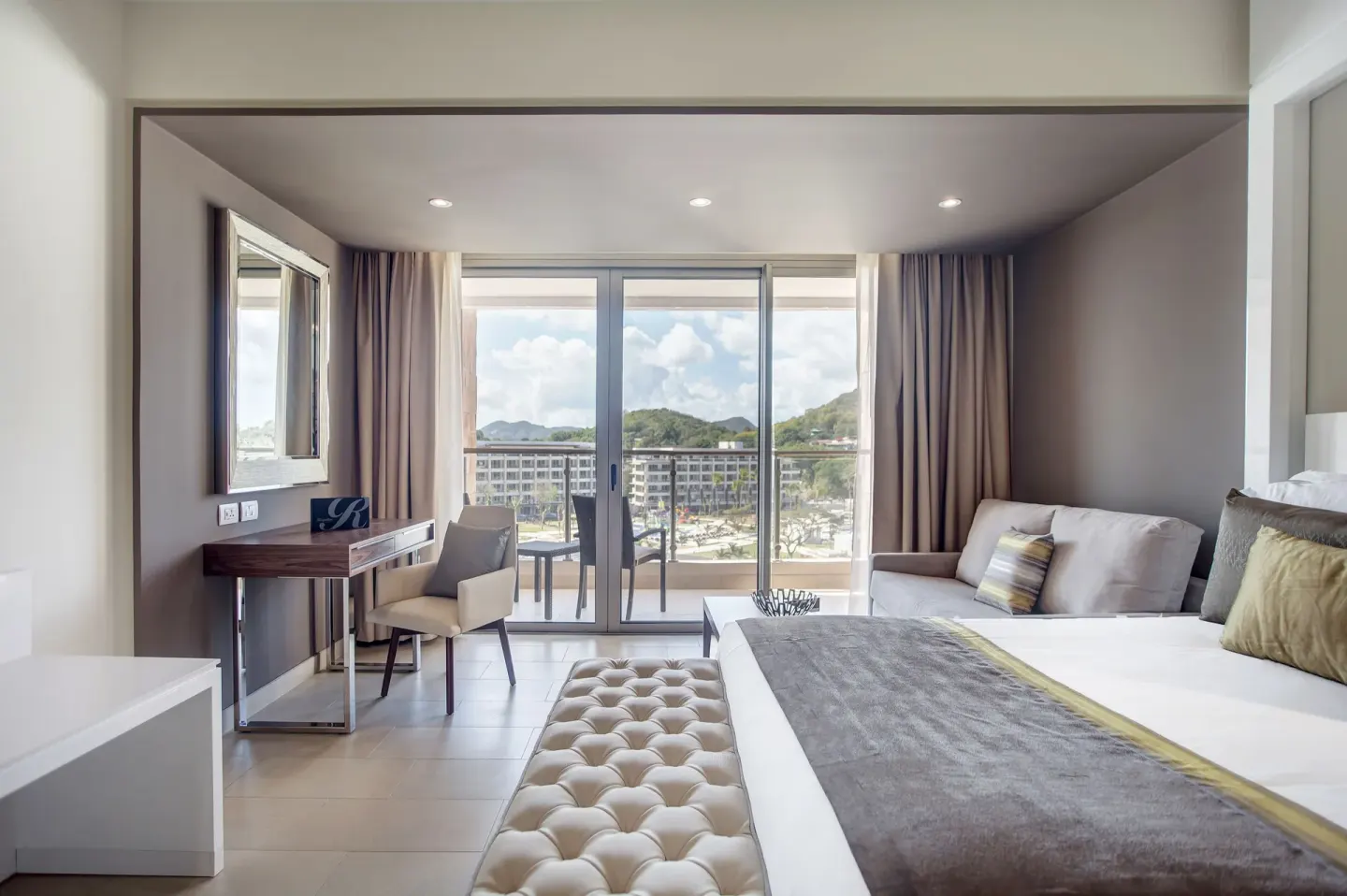 Luxury Junior Suite bed, sofa, desk and balcony at Royalton Hideaway Saint Lucia.