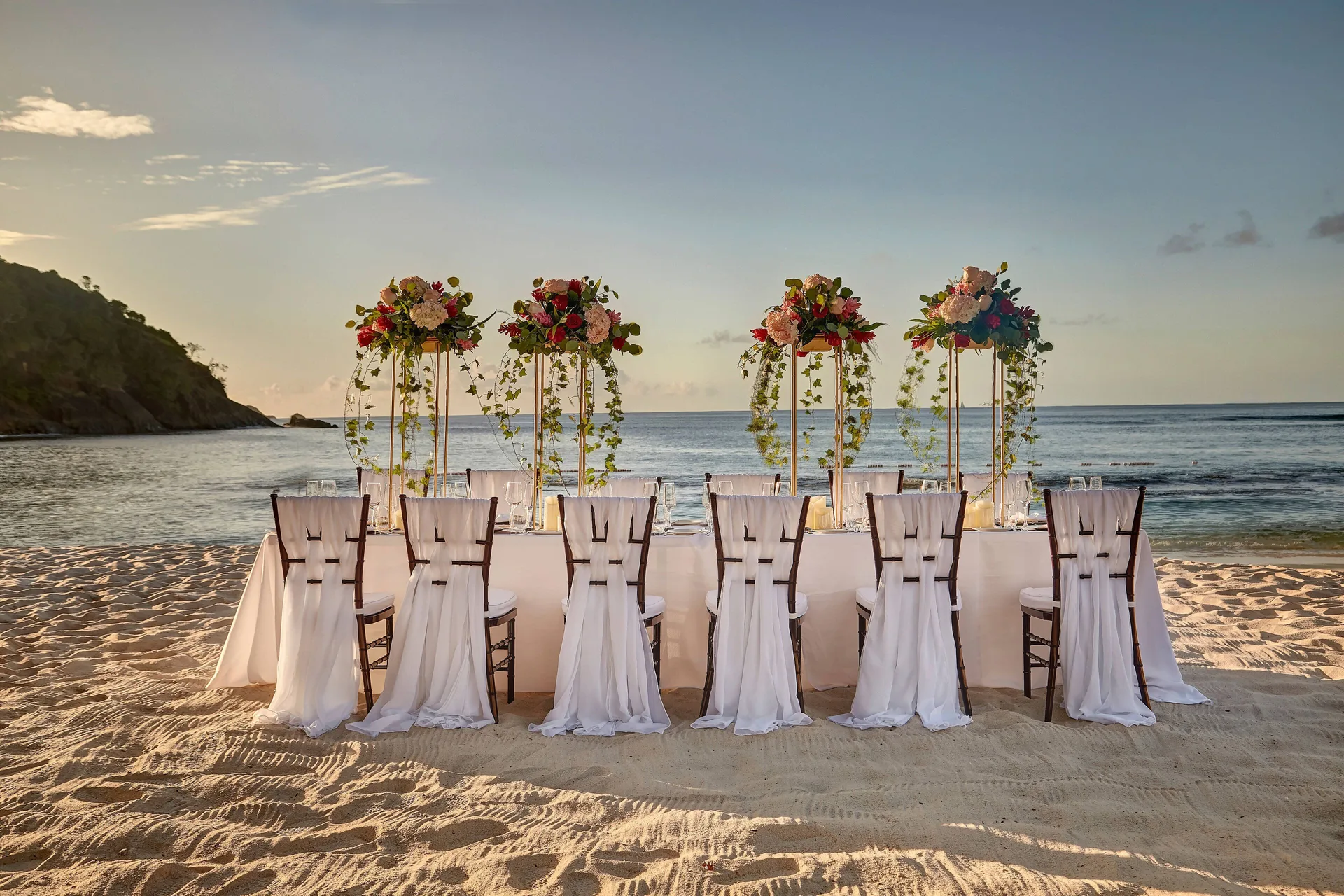 Beach wedding head table with floral hoops by the sea at Royalton Hideaway Saint Lucia.