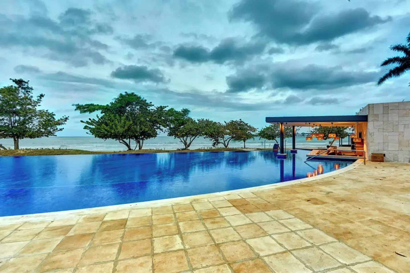 Infinity-style pool with ocean beyond and covered seating at Royalton Negril.