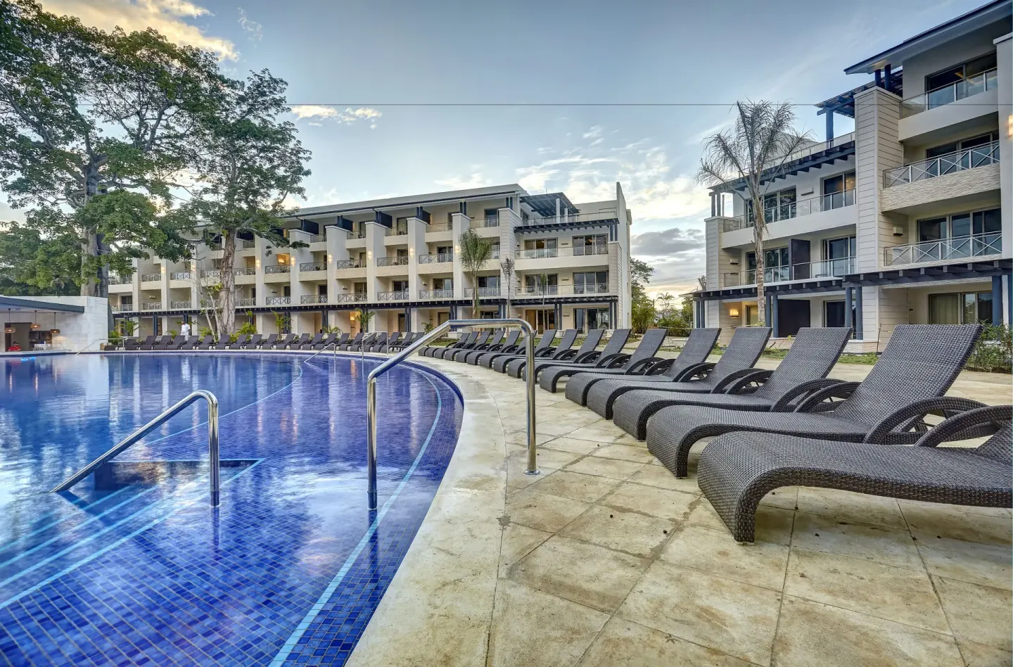 Poolside loungers beside guest buildings at Royalton Negril.