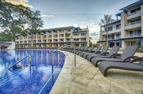 Poolside loungers beside guest buildings at Royalton Negril.