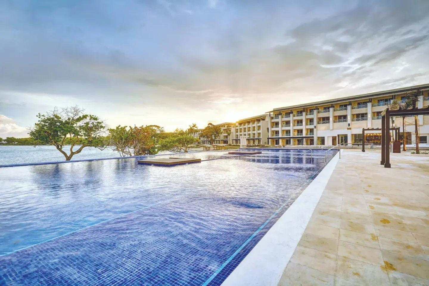 Reflecting pool and resort buildings at Royalton Negril at sunset.