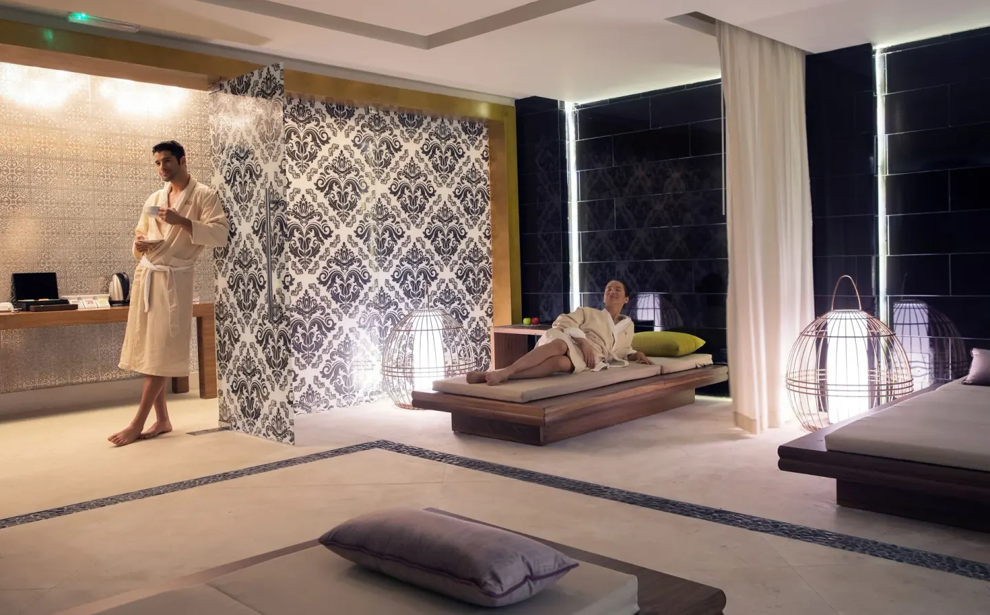 Guests in robes relax on loungers in the spa relaxation area at Royalton Negril.