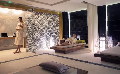 Guests in robes relax on loungers in the spa relaxation area at Royalton Negril.