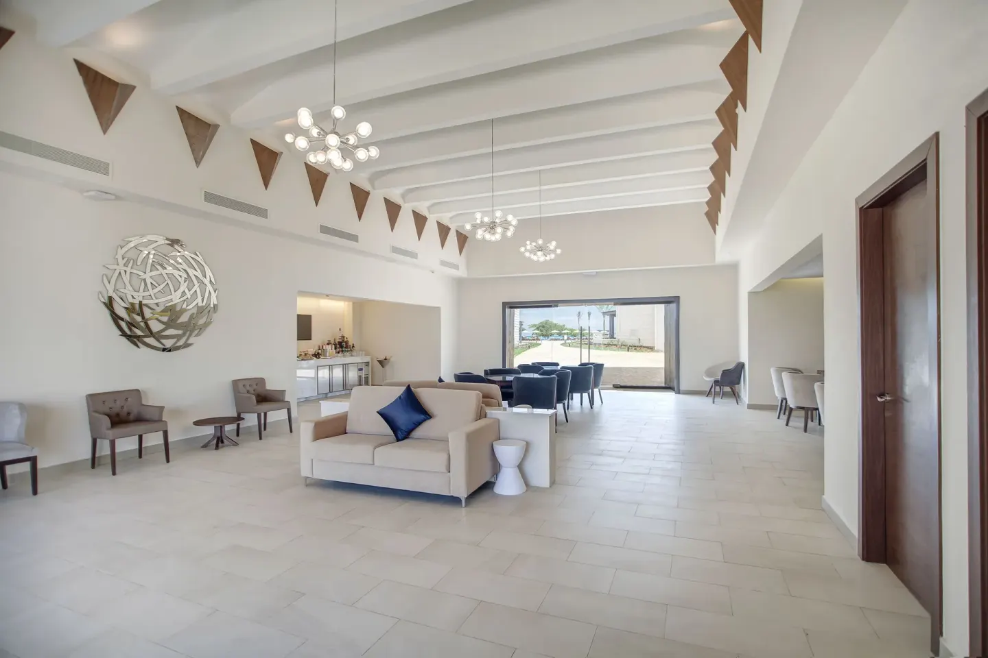 Spacious lounge with sofas, chandeliers, and wall art at Royalton Negril.