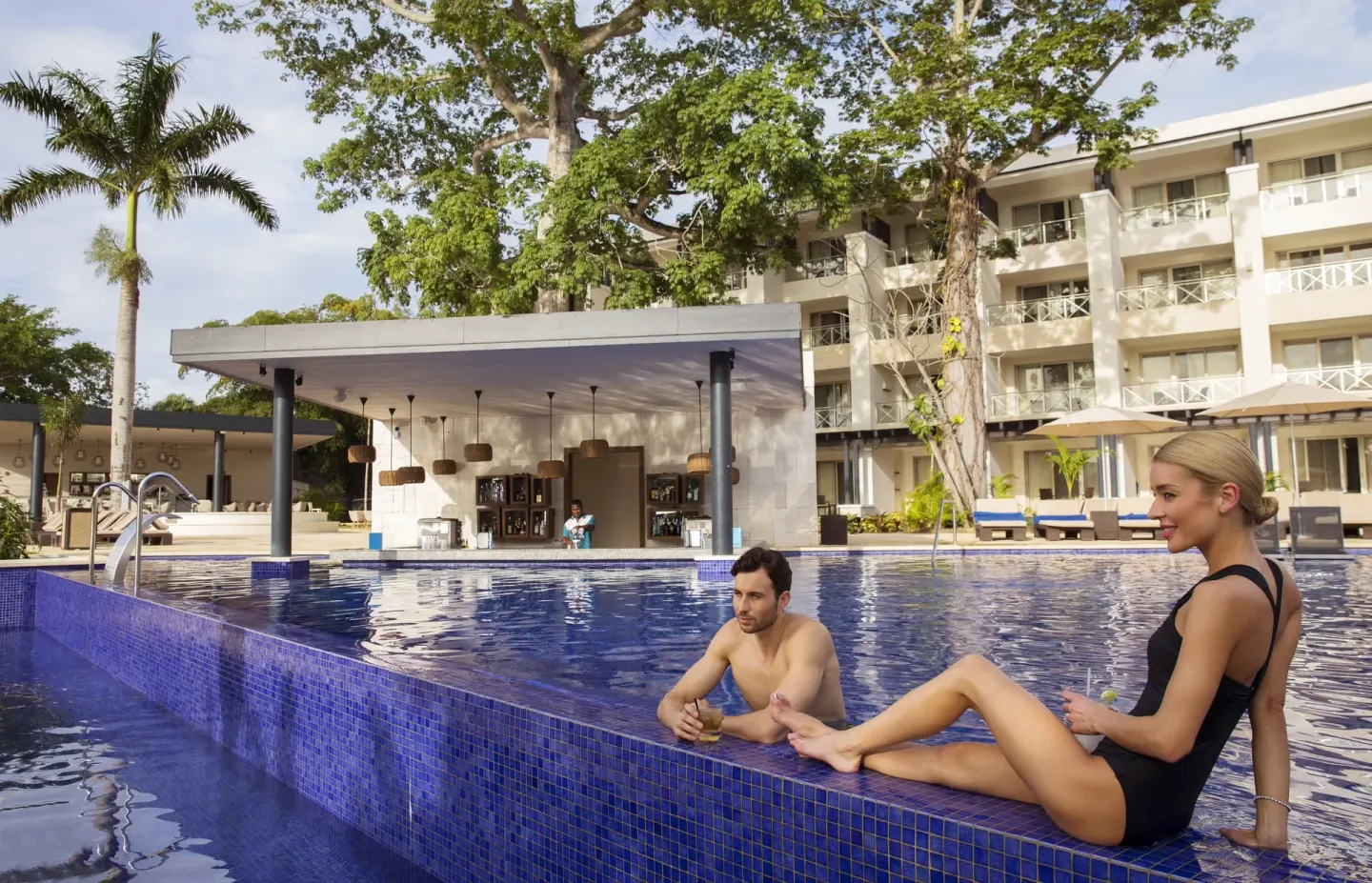 Guests relaxing at a swim-up bar pool at Royalton Negril.