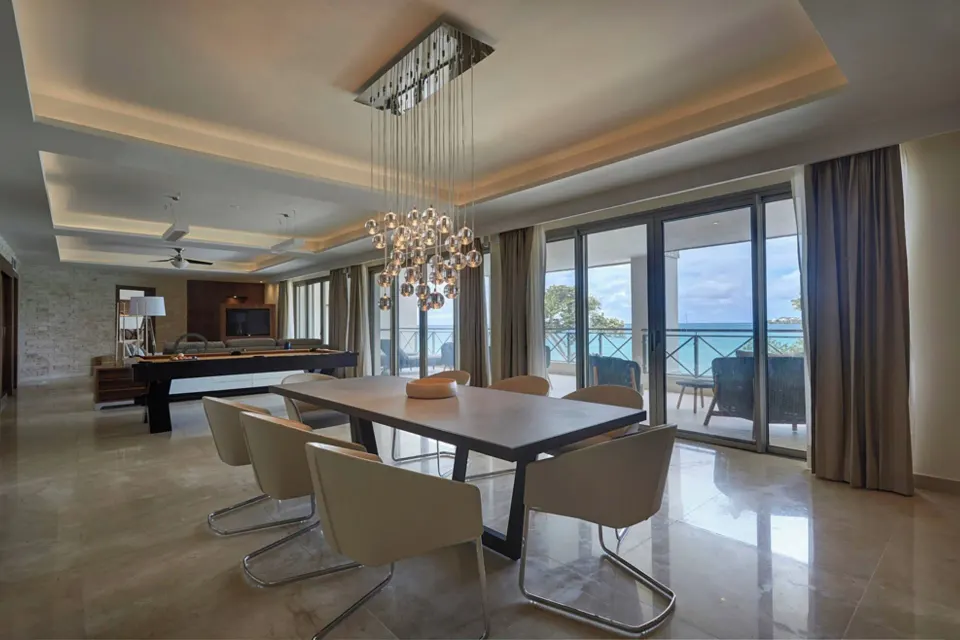 Dining table, pool table, and ocean-facing windows in the Chairman Suite at Royalton Negril.