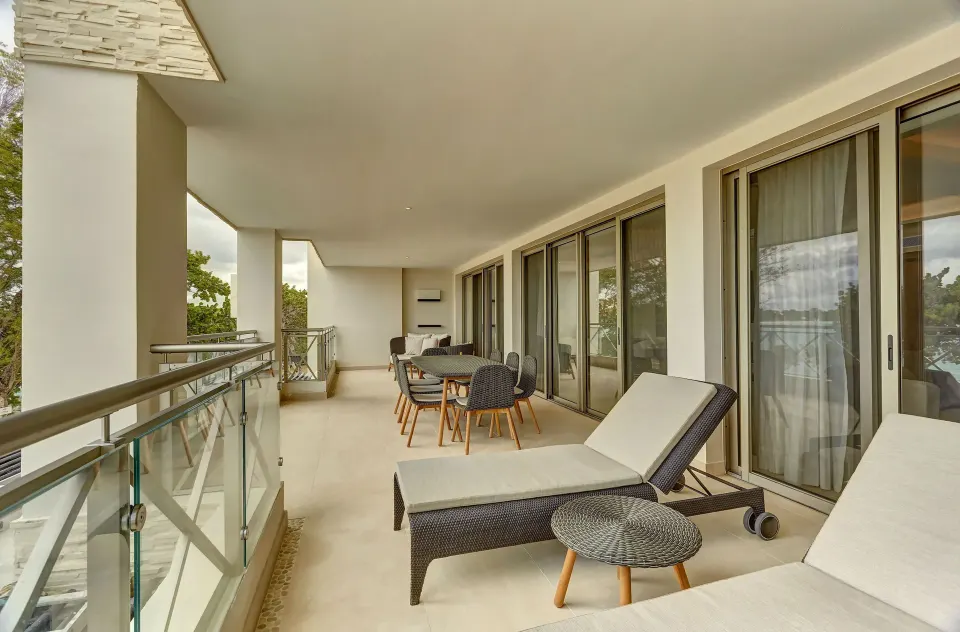 Oceanfront suite balcony with loungers and dining chairs at Royalton Negril.