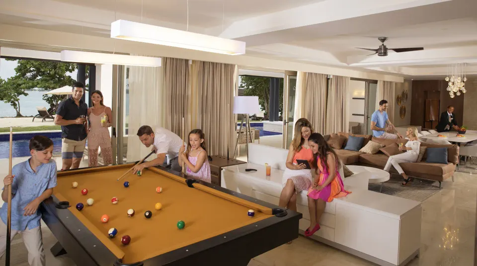 Oceanfront suite lounge with pool table and guests at Royalton Negril.