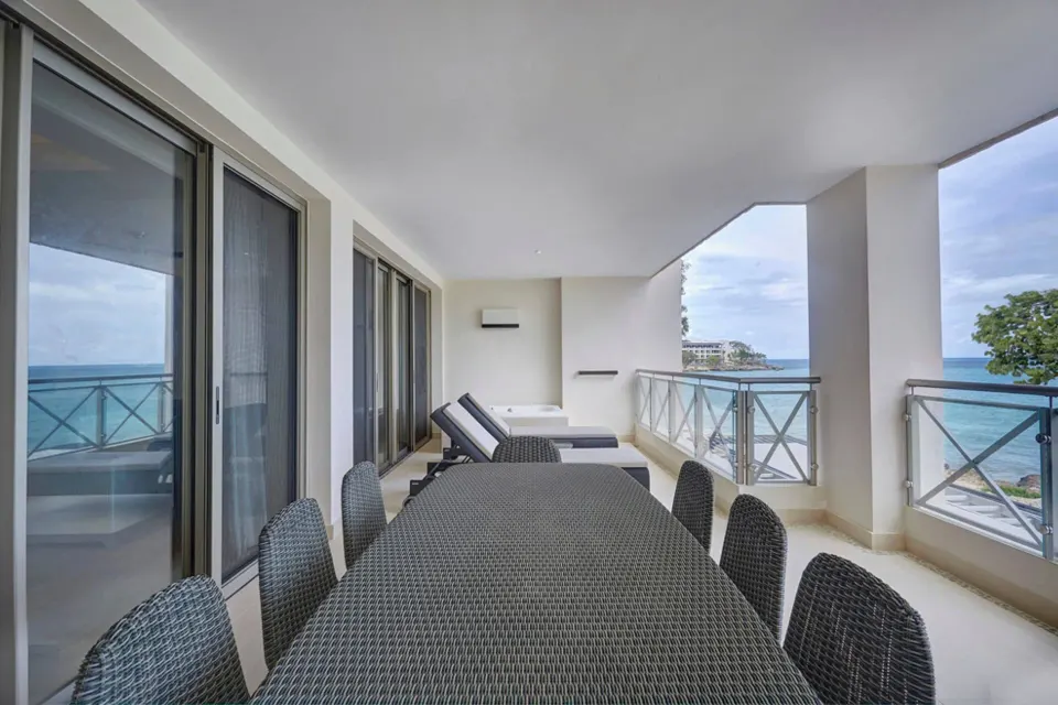 Oceanfront balcony with dining table and loungers in the Chairman Suite at Royalton Negril.
