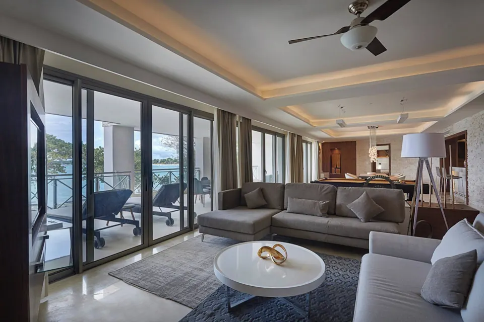 Oceanfront suite sitting area with sofas and balcony view at Royalton Negril.