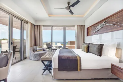 Ocean-view penthouse bedroom with king bed and terrace doors at Royalton Negril.