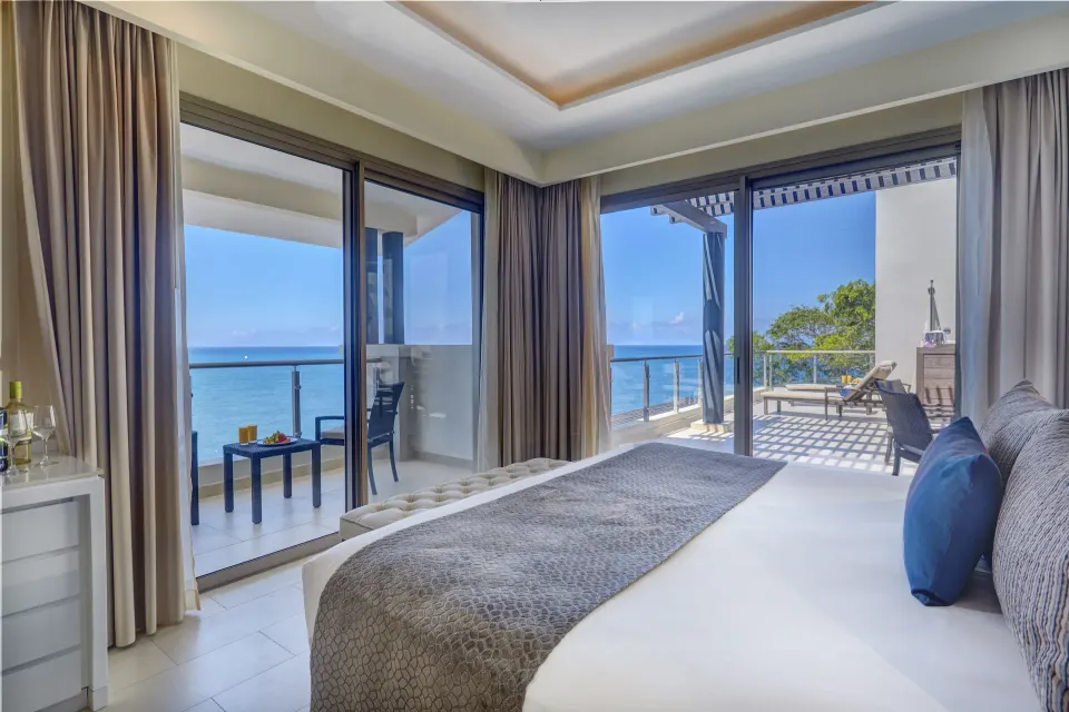 Penthouse suite king bed opening to ocean-view terraces at Royalton Negril.