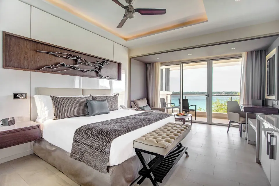 King bedroom with ocean-facing balcony in a Royalton Negril suite.