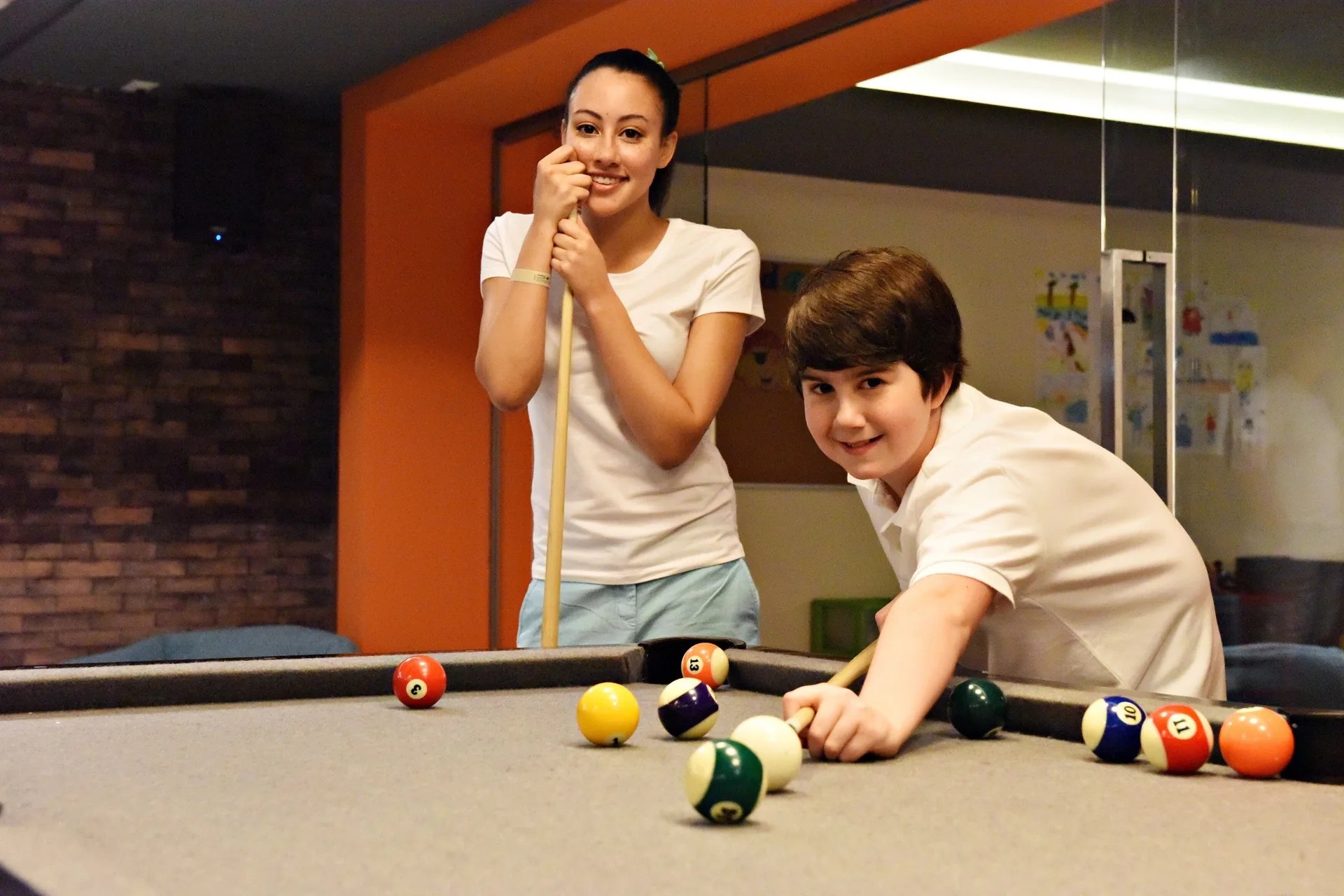 Two children play pool at a billiards table at Royalton Splash Riviera Cancun.