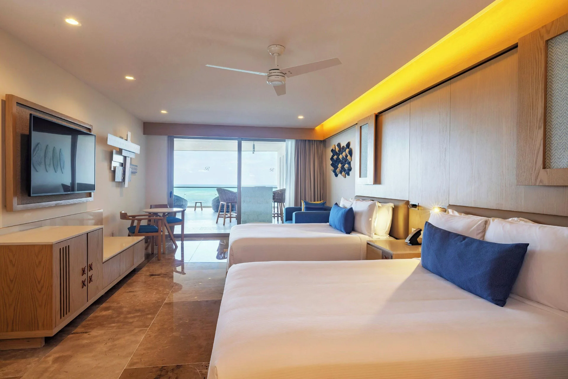 Guest room with two queen beds and balcony seating at Royalton Splash Riviera Cancun.