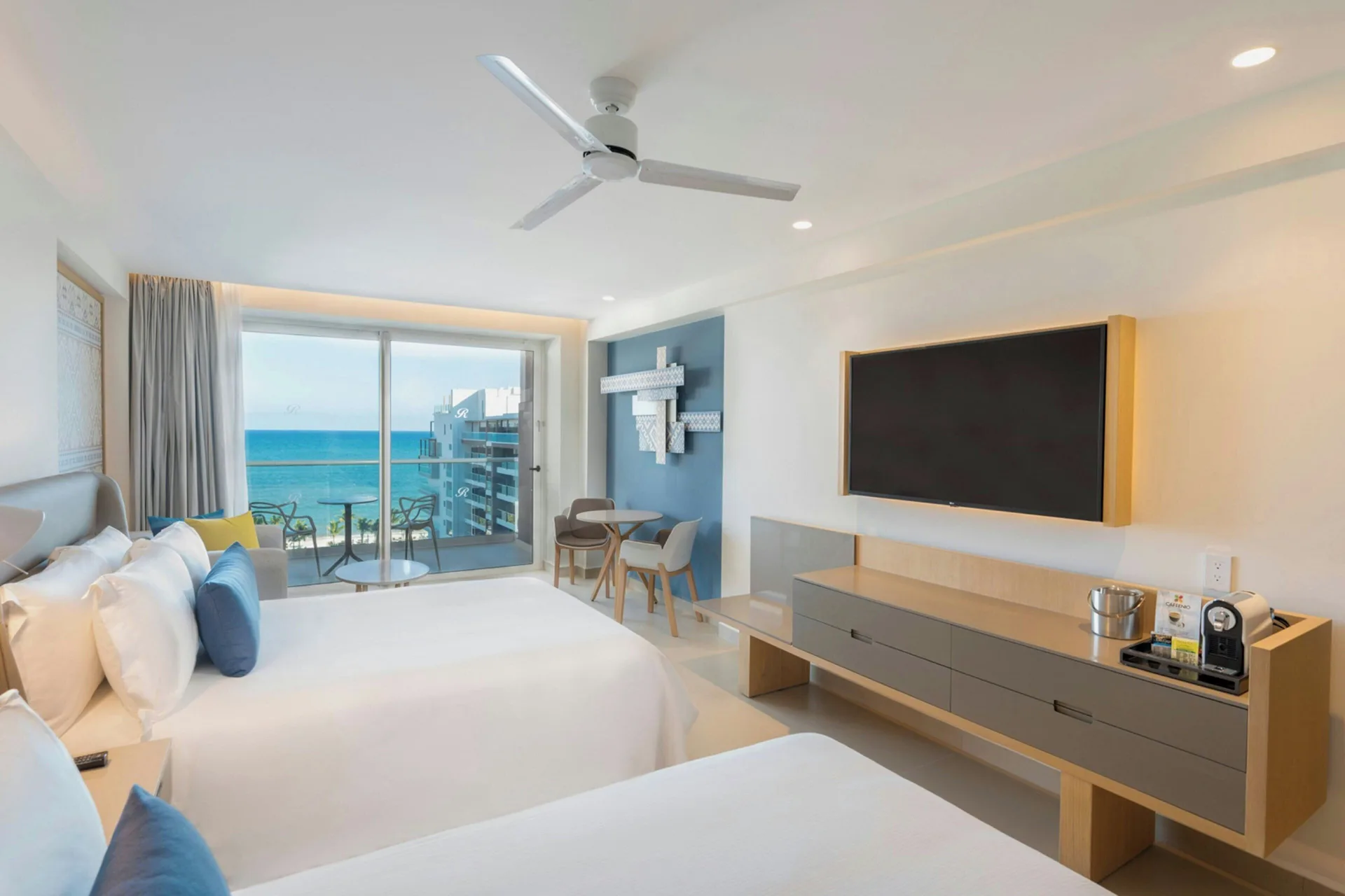 Two-bed ocean-view guest room with TV and balcony at Royalton Splash Riviera Cancun.