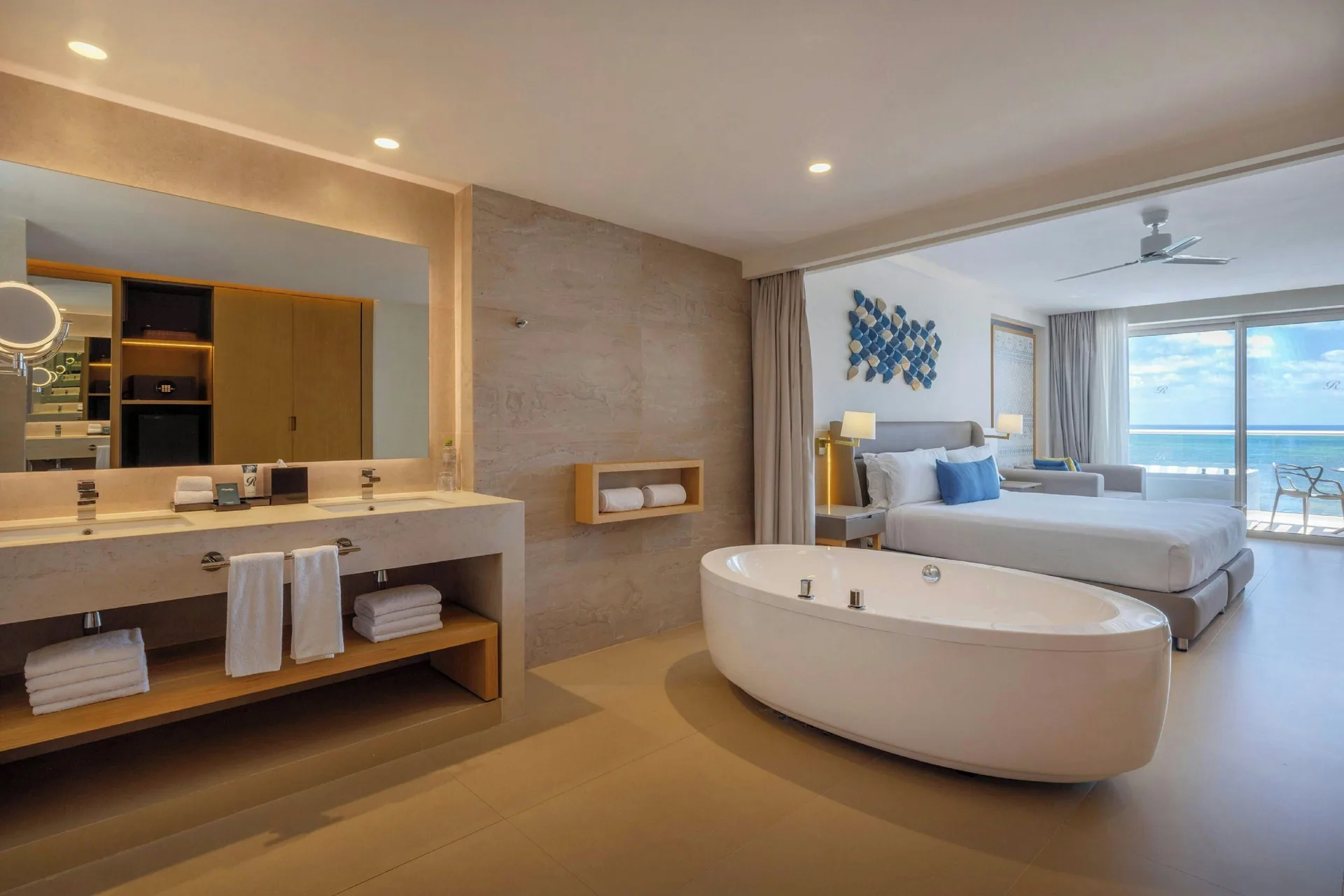 Suite with king bed, freestanding tub and ocean view at Royalton Splash Riviera Cancun.