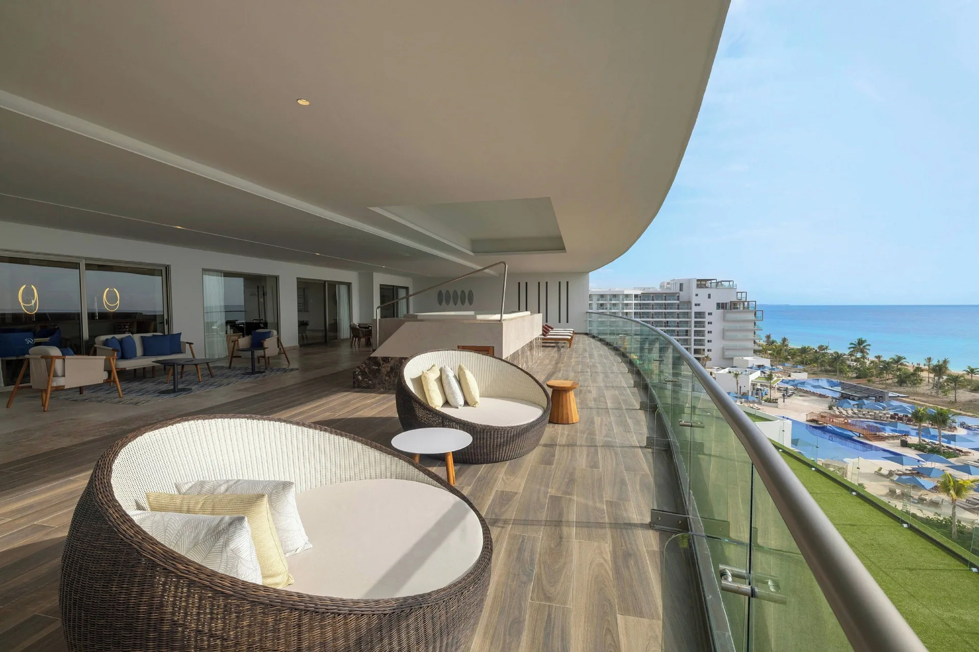 Large ocean-view suite terrace with round daybeds at Royalton Splash Riviera Cancun.
