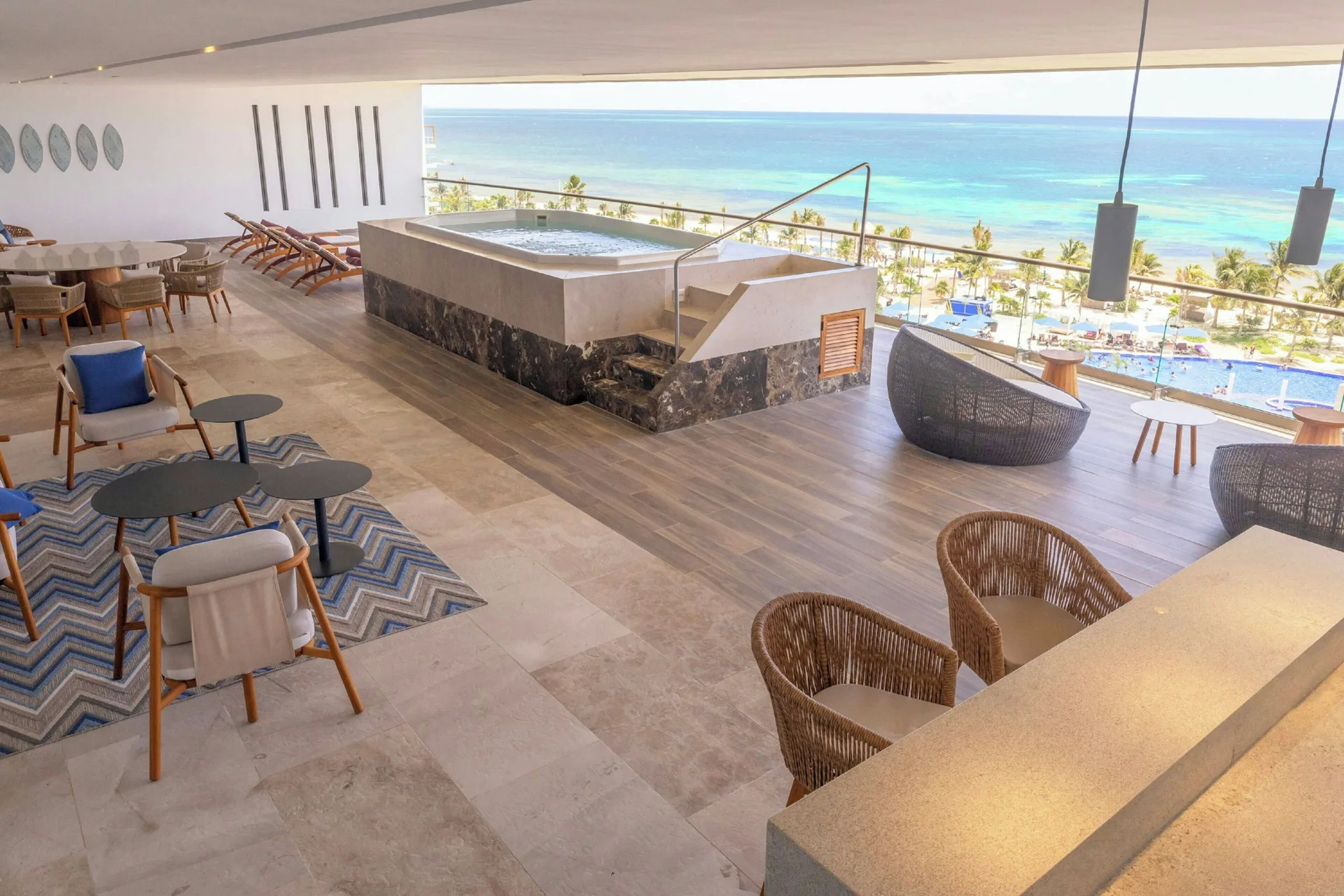Covered terrace lounge with hot tub and ocean view at Royalton Splash Riviera Cancun.