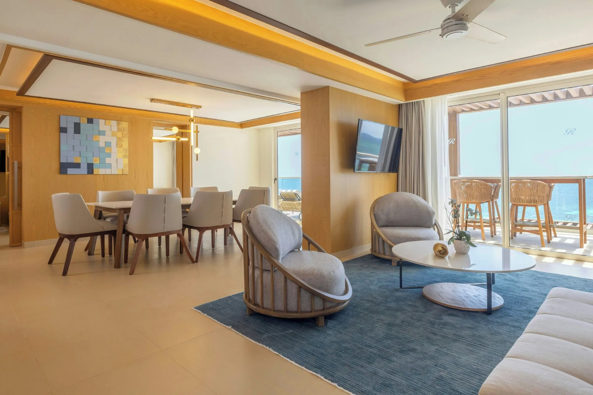 Oceanfront suite living and dining area with balcony at Royalton Splash Riviera Cancun.