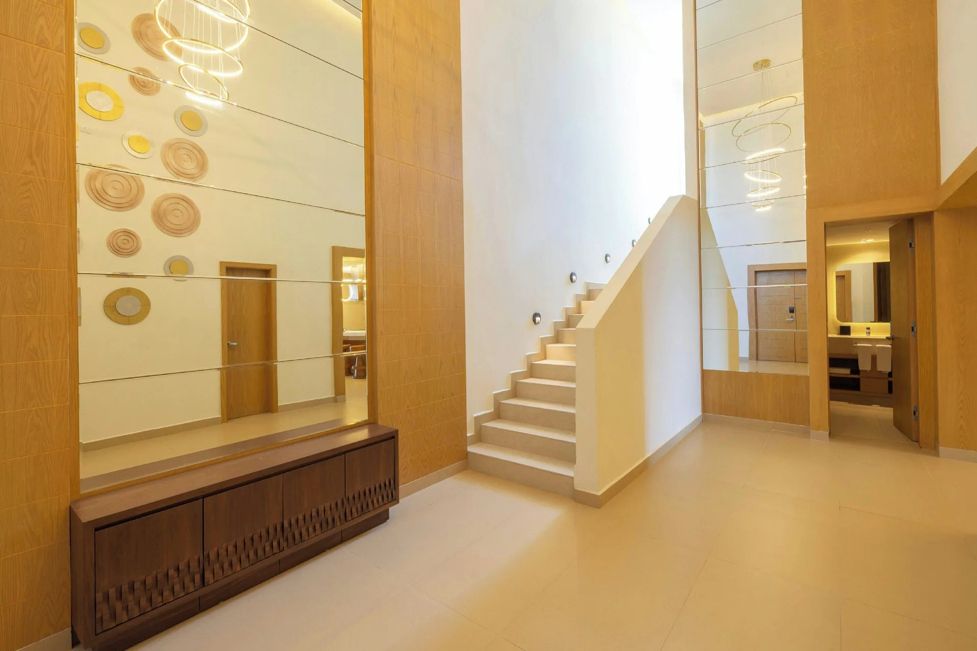 Tall suite foyer with staircase and mirrored wall at Royalton Splash Riviera Cancun.