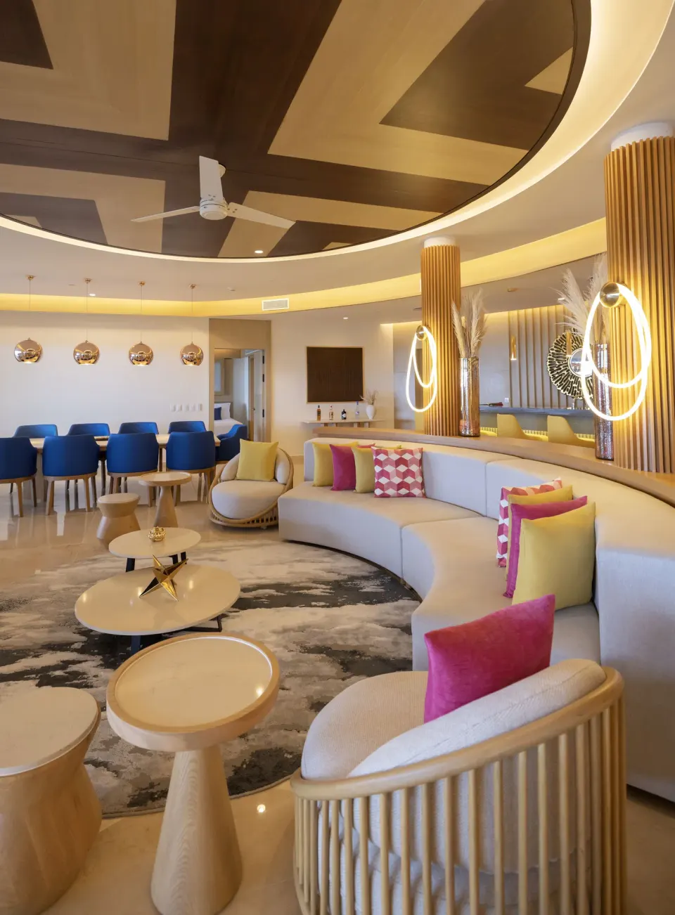 Curved sofa lounge and dining area in the Chairman Two Bedroom Suite at Royalton Splash Riviera Cancun.