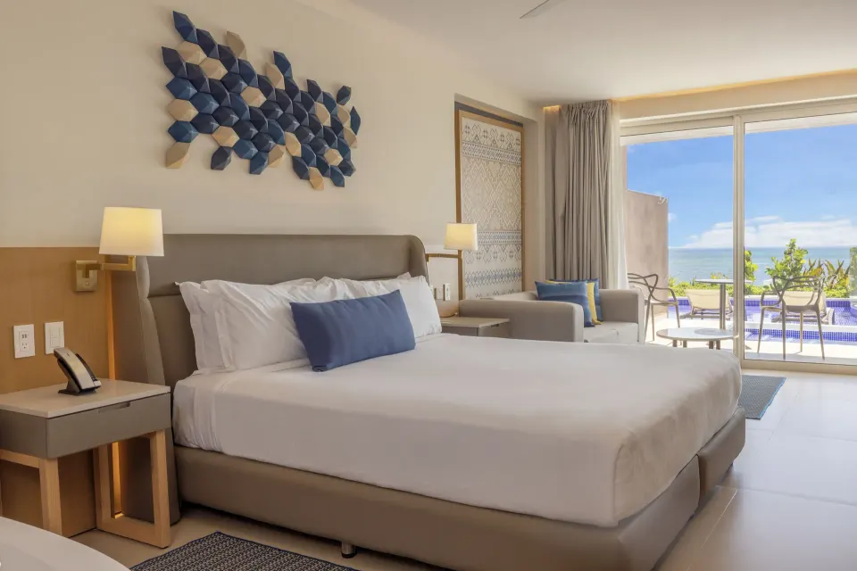 King bed and ocean-facing terrace in a swim-out suite at Royalton Splash Riviera Cancun.