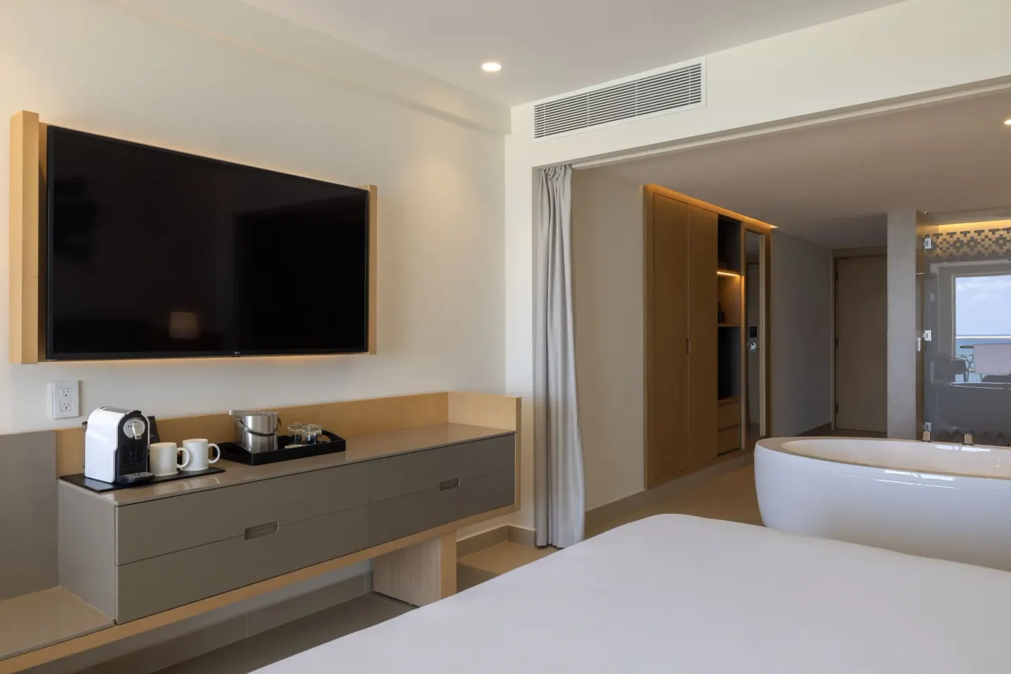 Suite media wall, beverage station, and soaking tub at Royalton Splash Riviera Cancun.
