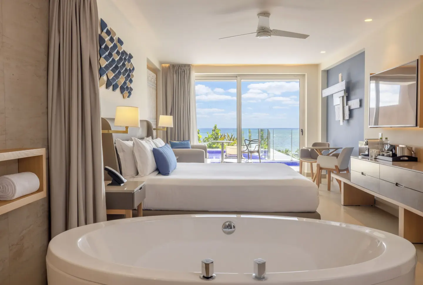 Ocean front swim-out suite with soaking tub and king bed at Royalton Splash Riviera Cancun.