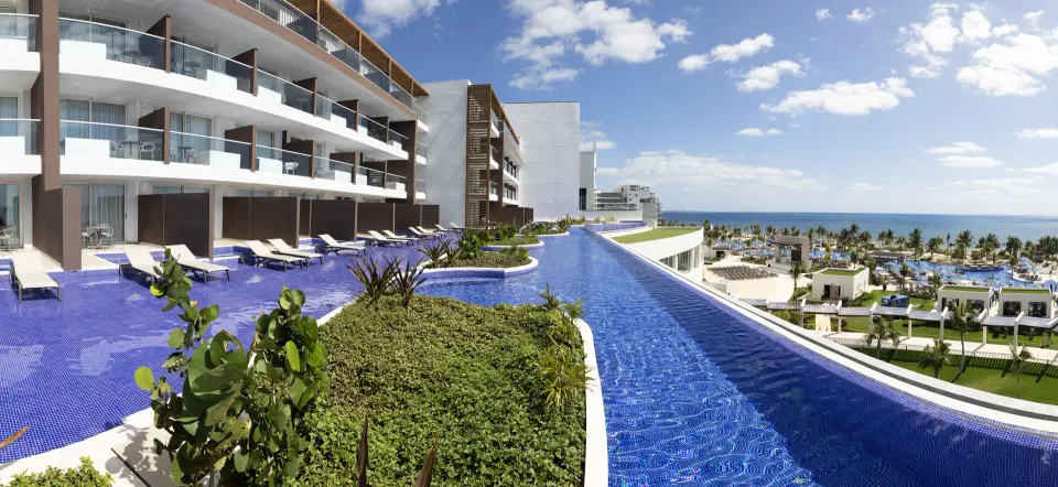 Curving swim-out pool beside oceanfront suites at Royalton Splash Riviera Cancun.