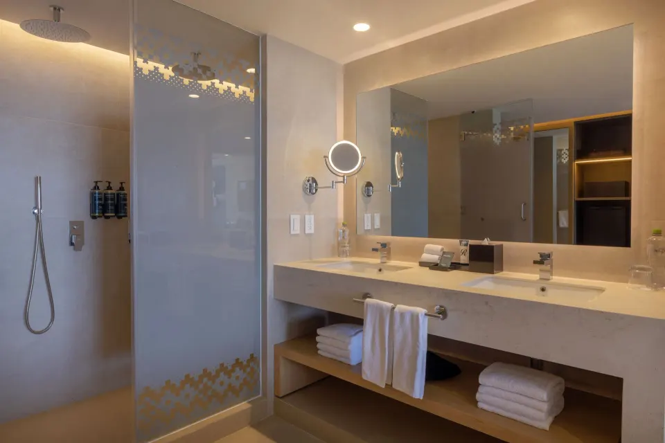 Double vanity and glass shower in a suite bathroom at Royalton Splash Riviera Cancun.