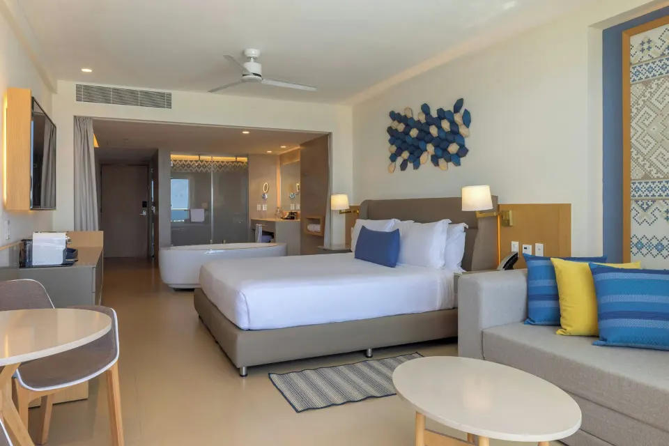 King bed junior suite with sofa and open bathroom at Royalton Splash Riviera Cancun.