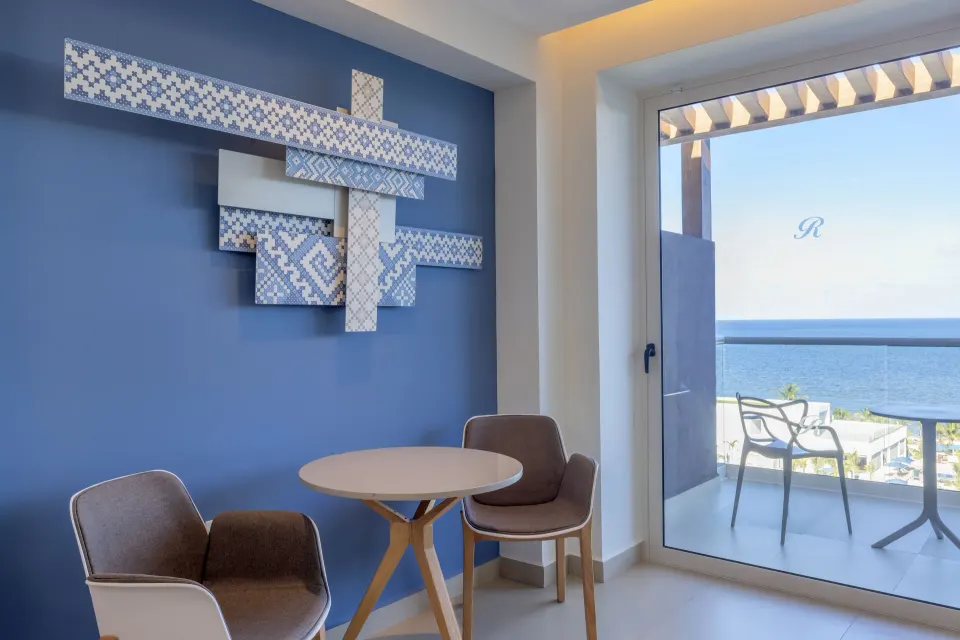 Seating nook and balcony ocean view in a Luxury Junior Suite Ocean Front at Royalton Splash Riviera Cancun.